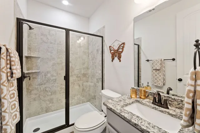 a bathroom with a granite countertop sink toilet and shower