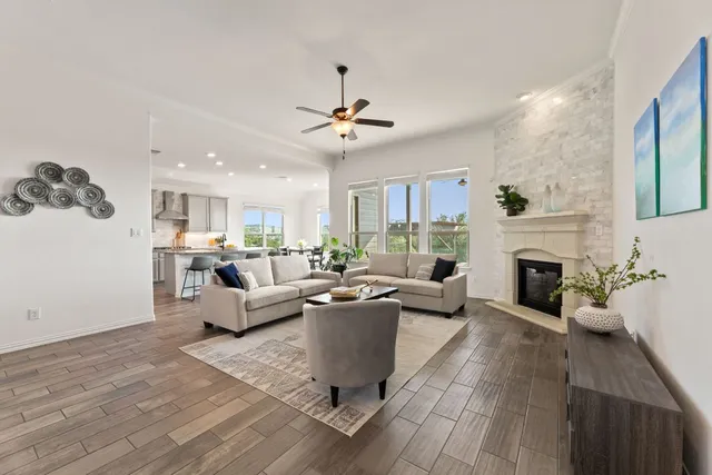 a living room with furniture a fireplace and a chandelier