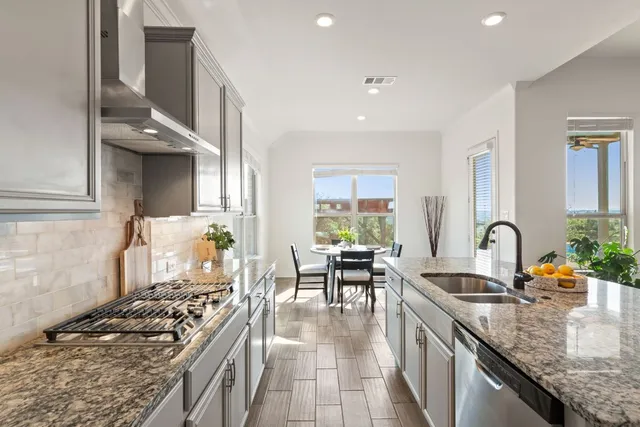 a kitchen with stainless steel appliances granite countertop a sink stove and cabinets
