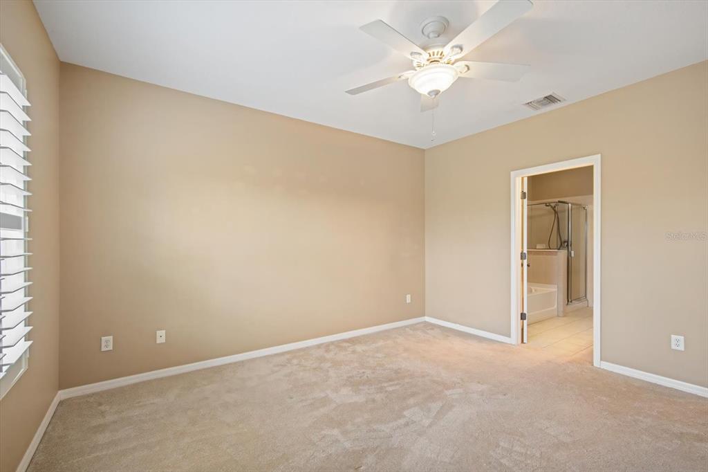 6142 Hadley Commons Drive Riverview, FL 33578 - Photo 17 of 29 an empty room with a chandelier fan and windows