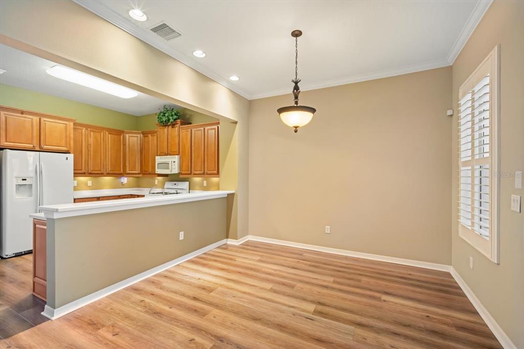6142 Hadley Commons Drive Riverview, FL 33578 - Photo 7 of 29 a kitchen with stainless steel appliances granite countertop a refrigerator a sink dishwasher a stove and white countertops with wooden floor