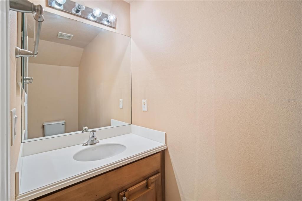6142 Hadley Commons Drive Riverview, FL 33578 - Photo 10 of 29 a bathroom with a granite countertop sink and a mirror