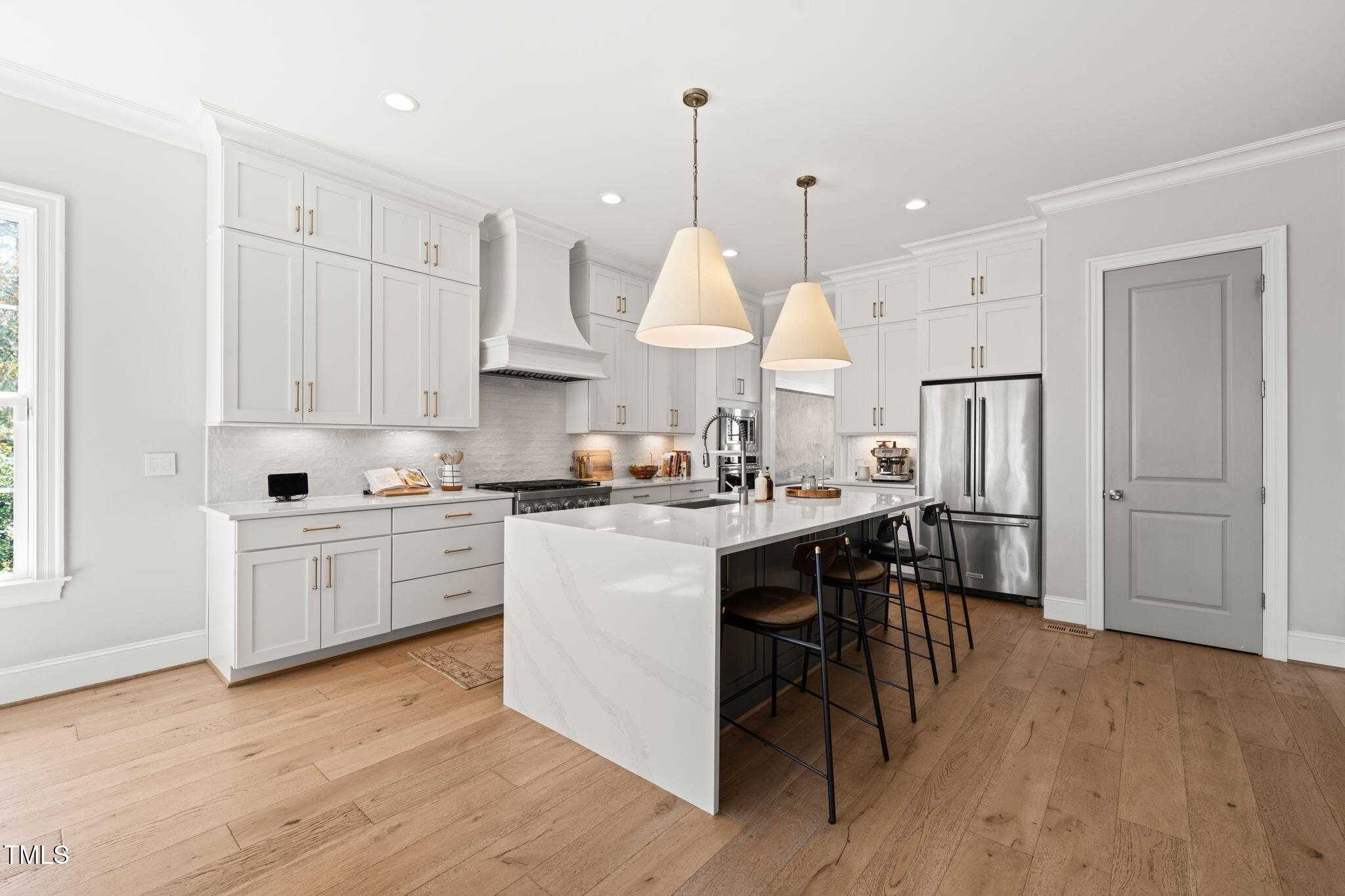2105 Gardenbrook Drive Raleigh, NC 27606 - Photo 16 of 86 a kitchen with kitchen island granite countertop wooden floors and white cabinets
