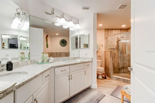 a spacious bathroom with a granite countertop sink mirror and shower