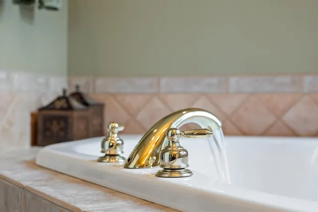 a bathroom with a tub a sink and mirror