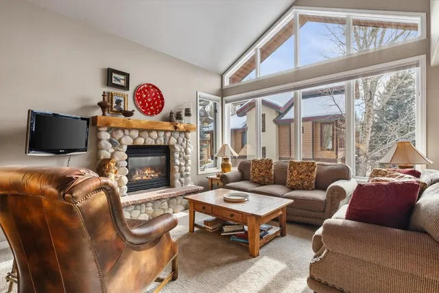 a kitchen with stainless steel appliances granite countertop a table chairs and a refrigerator