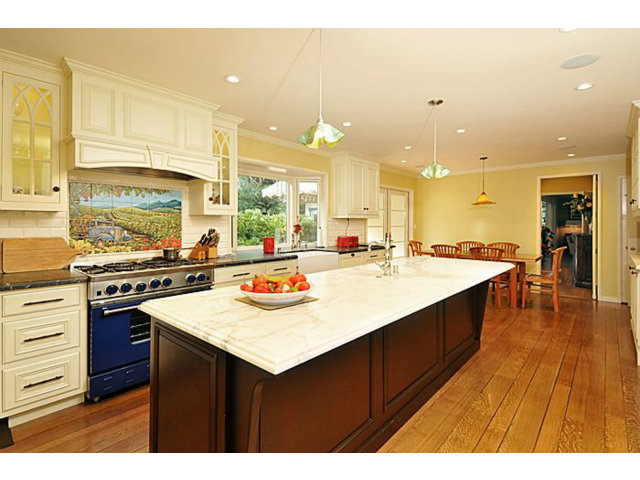 259 Bridge Road Hillsborough, CA 94010 - Photo 11 of 23 a open kitchen with kitchen island a sink dishwasher stove with a dining table and chairs