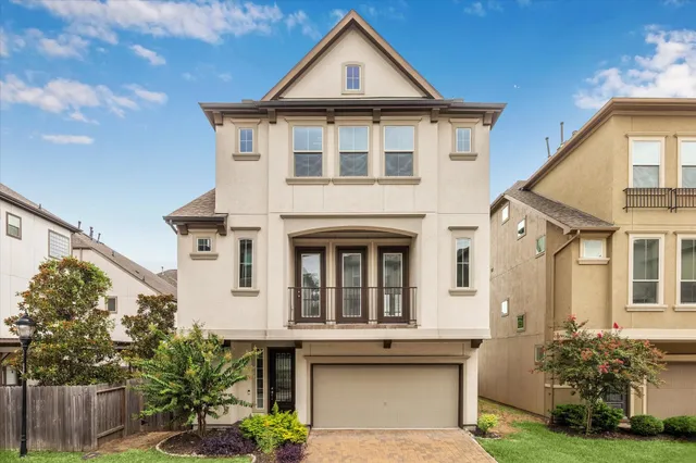 a view of a white house with large windows and a table and chairs
