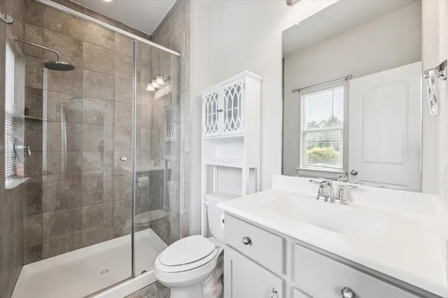 a bathroom with a sink a toilet and shower