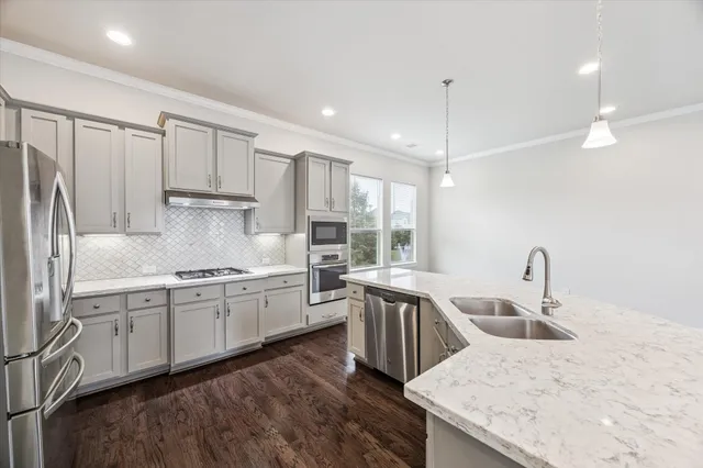 a kitchen with stainless steel appliances granite countertop a sink stove and refrigerator