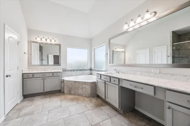 a large bathroom with a large tub sink and cabinets