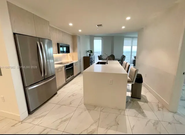a kitchen with stainless steel appliances granite countertop a refrigerator and a sink