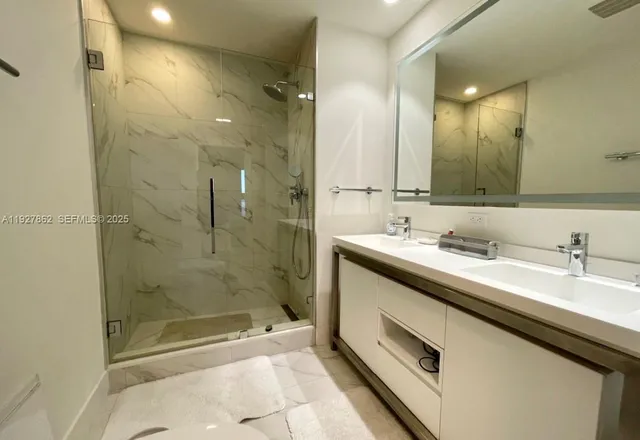 a bathroom with a granite countertop sink mirror and shower
