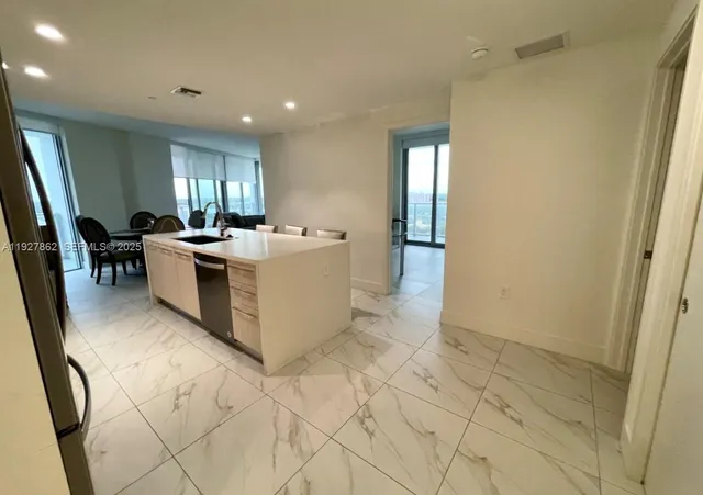 a view of a kitchen with kitchen island granite countertop lots of counter top space