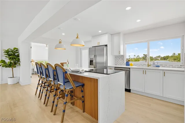 a kitchen with a table chairs sink and cabinets