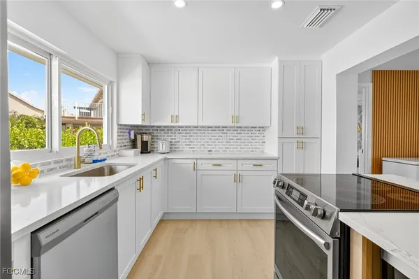 a kitchen with a sink a stove cabinets and counter space