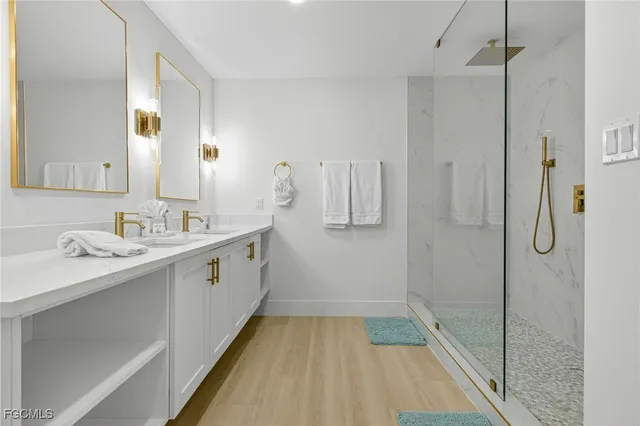 a bathroom with a double vanity sink mirror and shower
