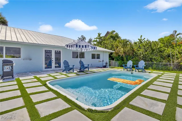 a view of a backyard with swimming pool table and chairs