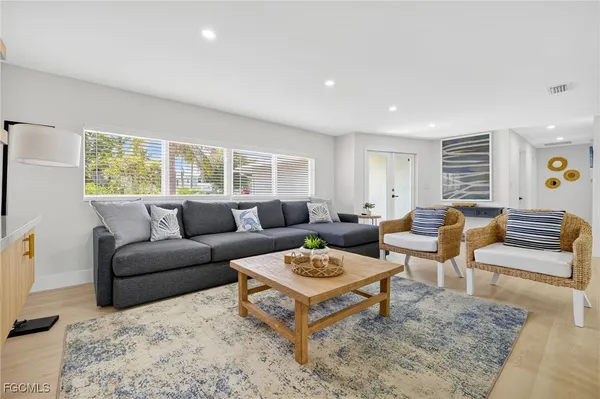 a living room with furniture a rug and a window