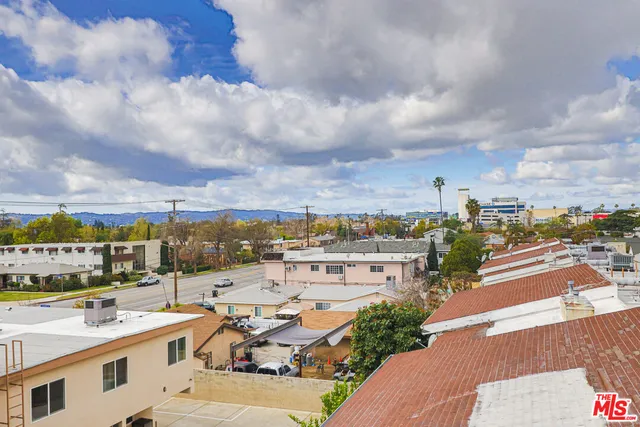 a view of a terrace with lawn chairs and city view