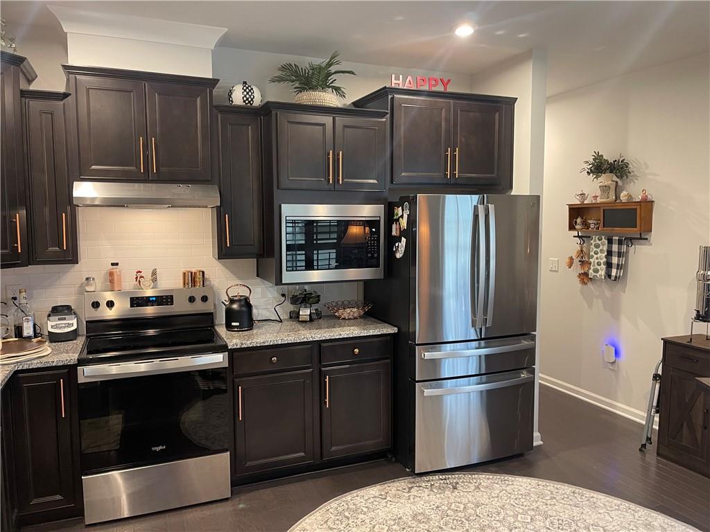 5709 Grapewood Street Hoschton, GA 30548 - Photo 16 of 65 a kitchen with a sink appliances and cabinets