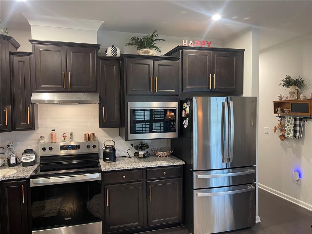 5709 Grapewood Street Hoschton, GA 30548 - Photo 18 of 65 a kitchen with granite countertop a refrigerator stove and sink