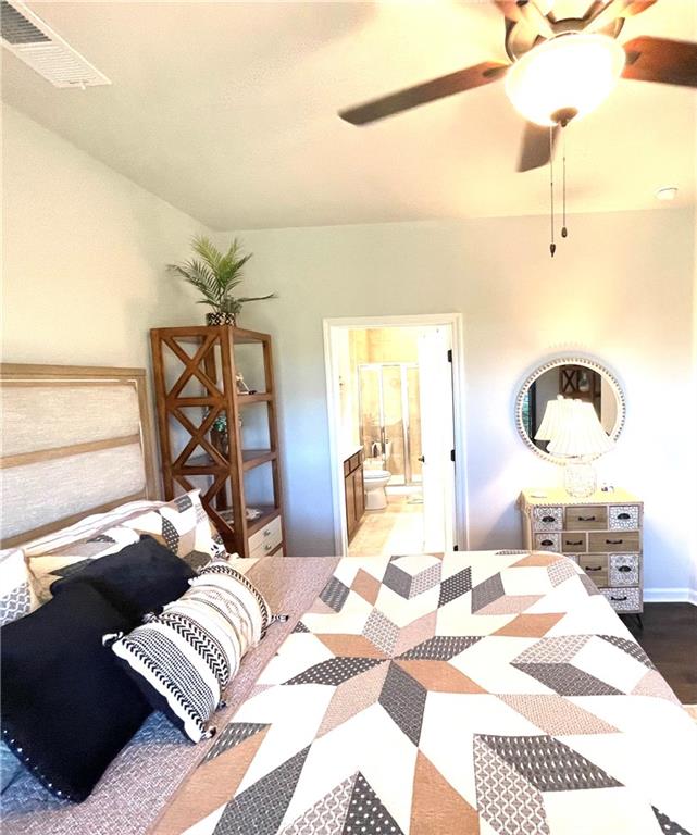 5709 Grapewood Street Hoschton, GA 30548 - Photo 27 of 65 a bedroom with a bed and wooden floor