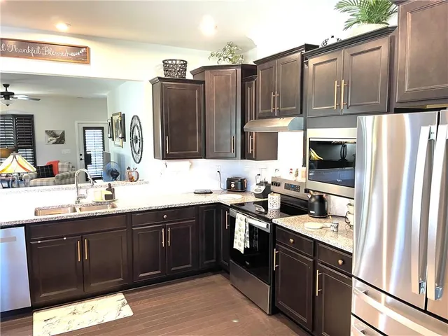 a kitchen with stainless steel appliances granite countertop a refrigerator and a sink