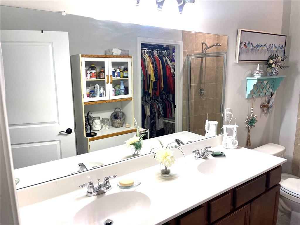 5709 Grapewood Street Hoschton, GA 30548 - Photo 32 of 65 a bathroom with a sink vanity and a mirror