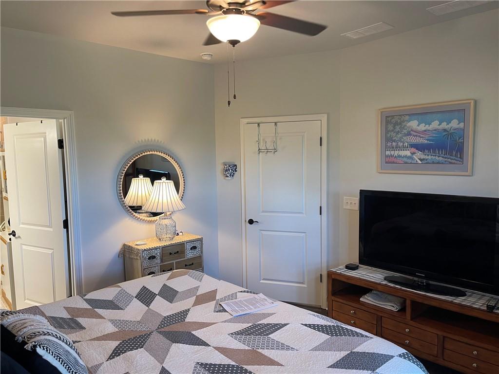 5709 Grapewood Street Hoschton, GA 30548 - Photo 33 of 65 a bedroom with a bed and a flat screen tv