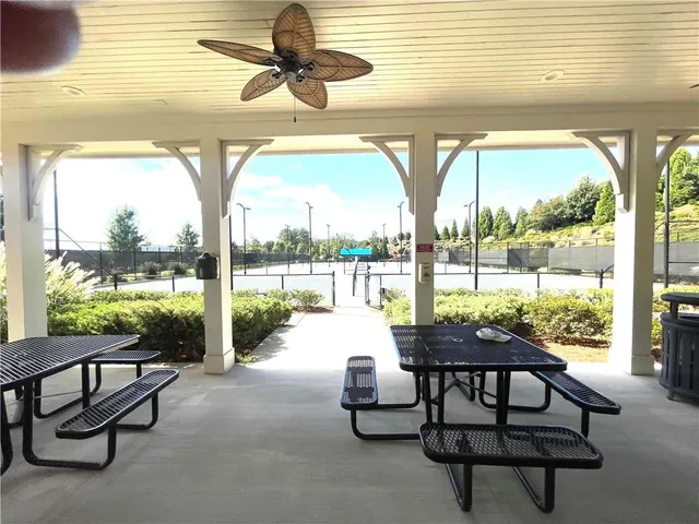 a view of a house with large windows and plants