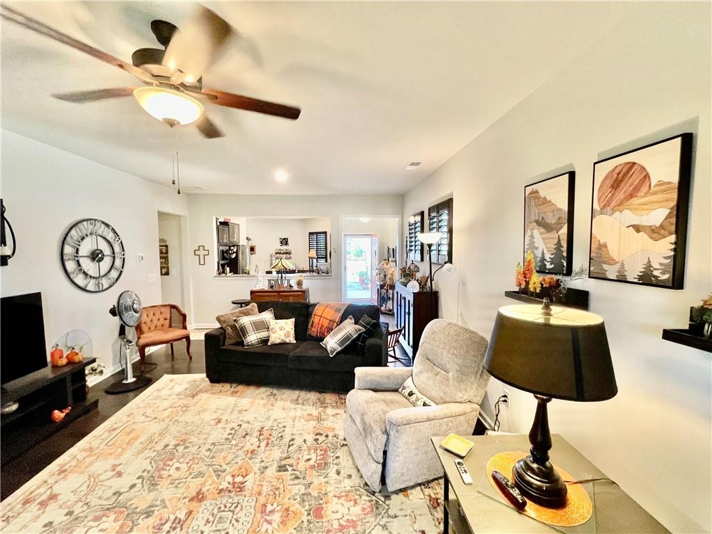 5709 Grapewood Street Hoschton, GA 30548 - Photo 52 of 65 a living room with furniture a large window and a chandelier