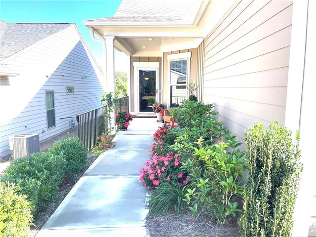a living room with furniture a flat screen tv and kitchen view