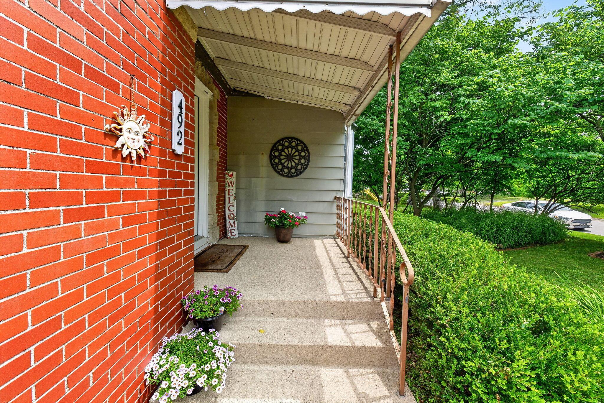 492 Wetmore Road Columbus, OH 43214 - Photo 12 of 55 Inviting front porch with a white aluminum awning and decorative metal railing