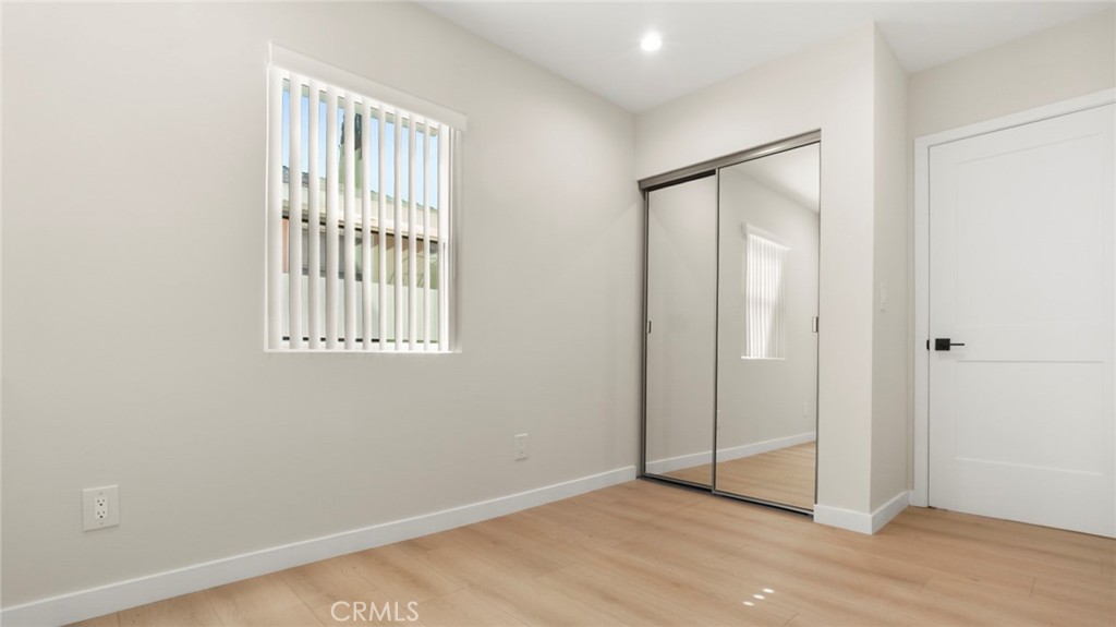19928 Hatton Street Winnetka, CA 91306 - Photo 12 of 15 an empty room with wooden floor and windows