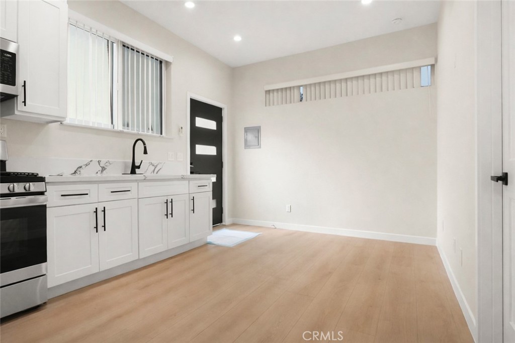 19928 Hatton Street Winnetka, CA 91306 - Photo 6 of 15 a kitchen with white cabinets and white appliances