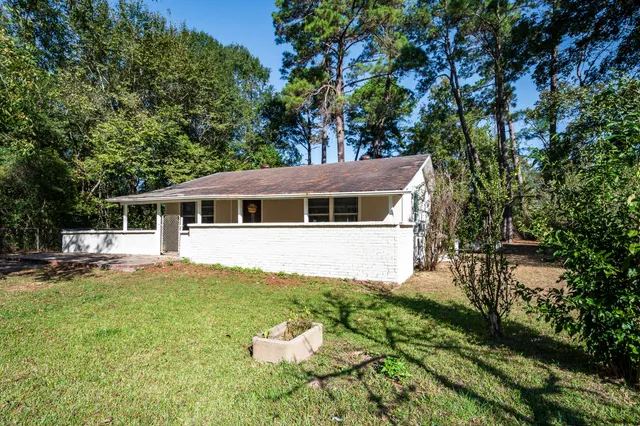 a front view of a house with a yard and trees