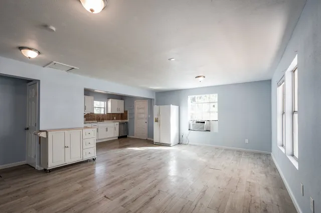 a view of a kitchen with wooden floor and window