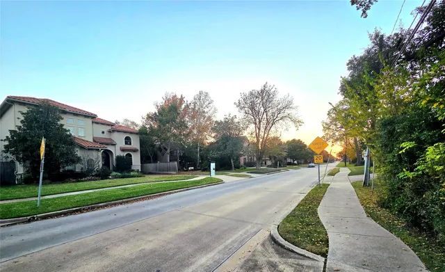 a view of a white house in a big yard with palm trees