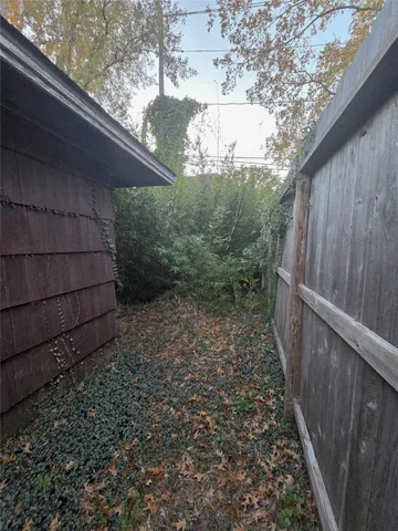 a view of a pathway of a house with wooden fence