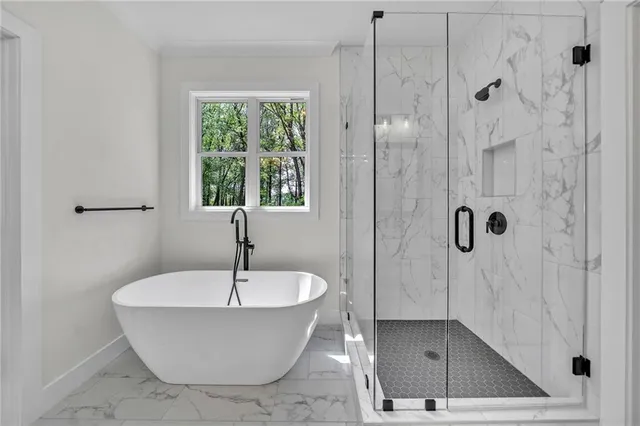a bathroom with a granite countertop sink toilet a large mirror a bathtub and shower