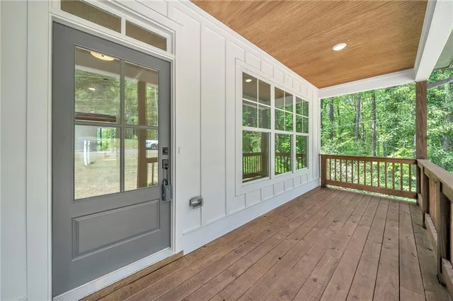 a view of a hallway with wooden floor and a window