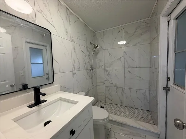 a bathroom with a sink a toilet and shower
