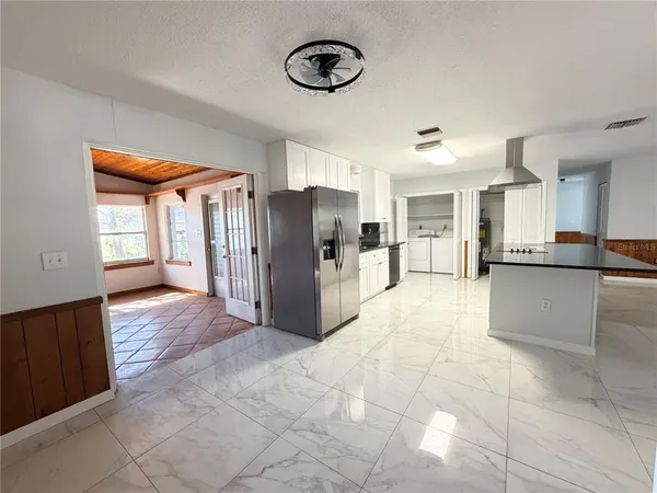 a view of a kitchen with refrigerator and window