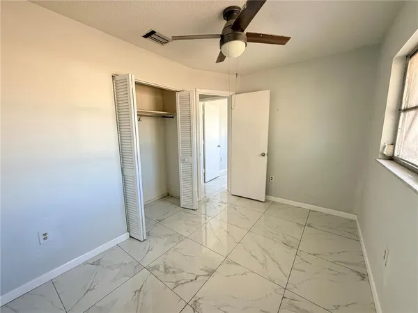 an empty room with windows and closet
