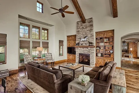a living room with furniture large window and fireplace