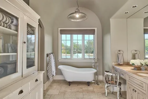 a spacious bathroom with a tub sink and mirror