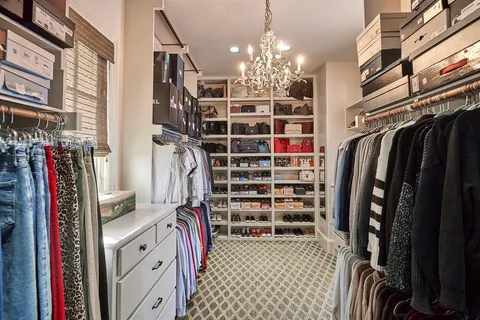 a view of walk in closet with clothes and shoes
