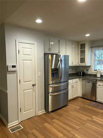 a kitchen with a refrigerator and a stove top oven