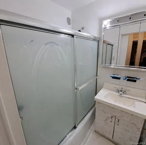 a bathroom with a sink mirror and shower